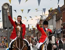 Cornet and lass cheering at crowds on High Street
